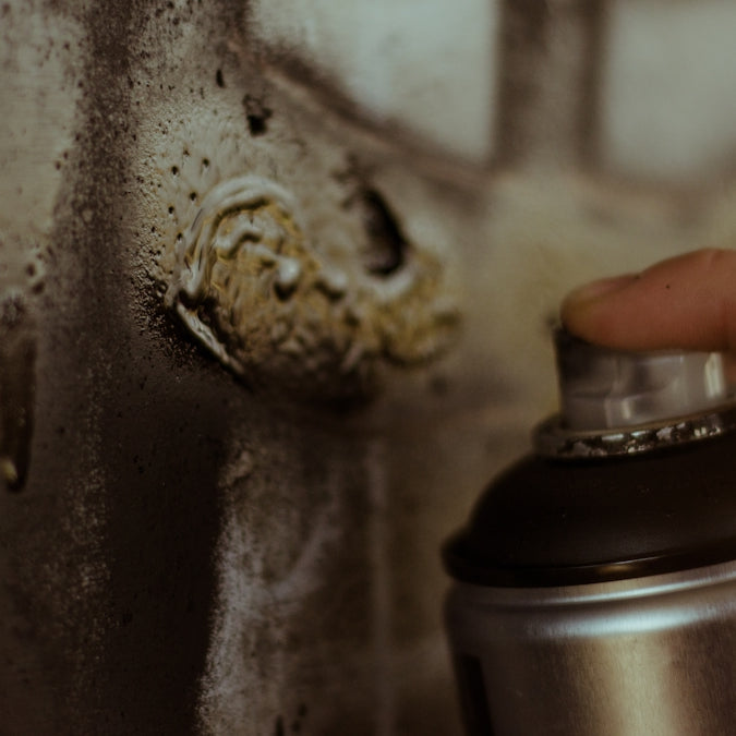 person holding gray spray can