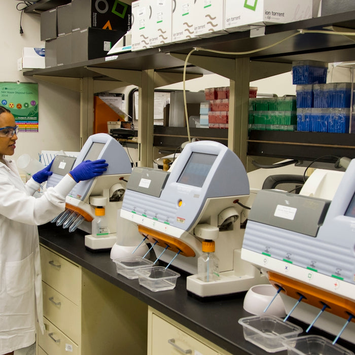 person in white medical scrub suit standing beside white and blue hospital bed