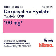 Close-up of Doxycycline Hyclate 100 mg tablets label with pink dosage area, black text, Rx only, 50 tablets, distributed by Hikma Pharmaceuticals