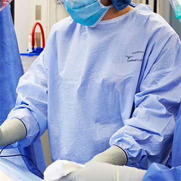SmartGown AAMI Level 4 surgical gown in blue, providing maximum protection and comfort with breathable material; ideal for healthcare professionals, pictured during use in a medical setting.